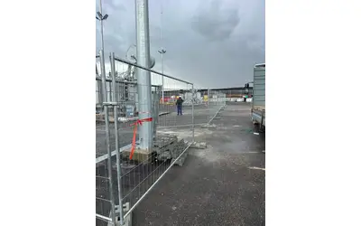 גדר זמנית מגולוונת עם בסיסי משקולת סביב שנאי חשמל באתר תשתית