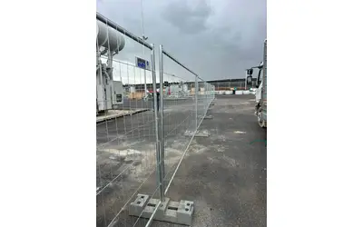 התקנת גדר זמנית מגולוונת עם בסיסים כבדים באתר תעשייתי